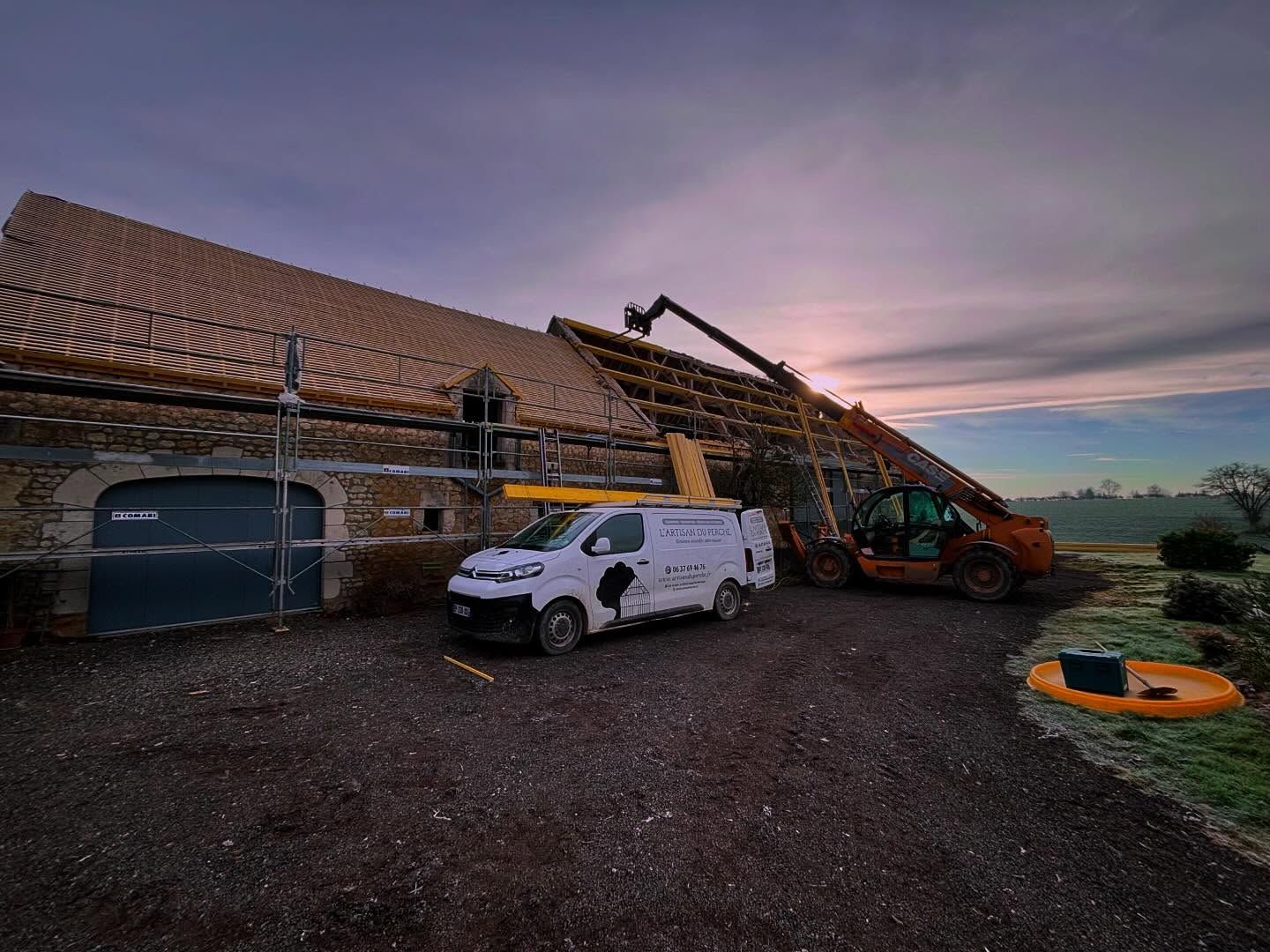Une maison en travaux sous un coucher de soleil.