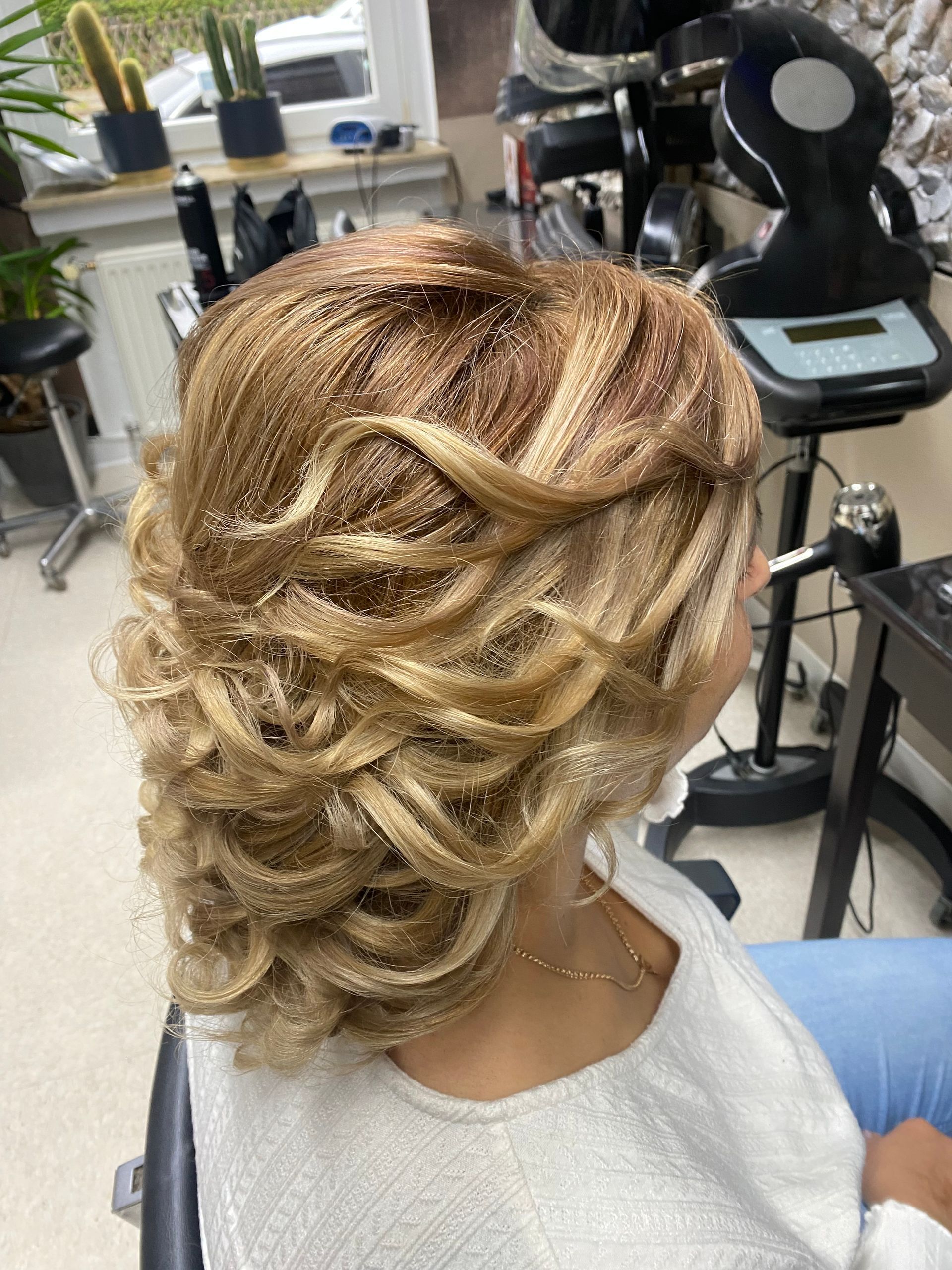 Eine Frau sitzt mit einem Haarknoten auf einem Stuhl.