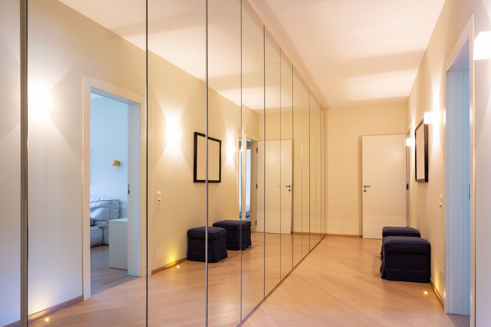 Miroirs montés sur des portes de dressing dans un couloir.