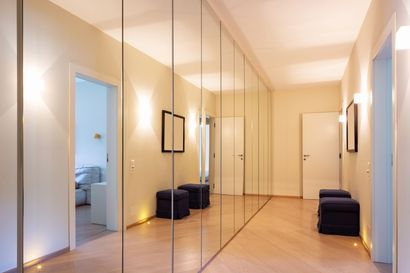 Miroirs montés sur des portes de dressing dans un couloir.