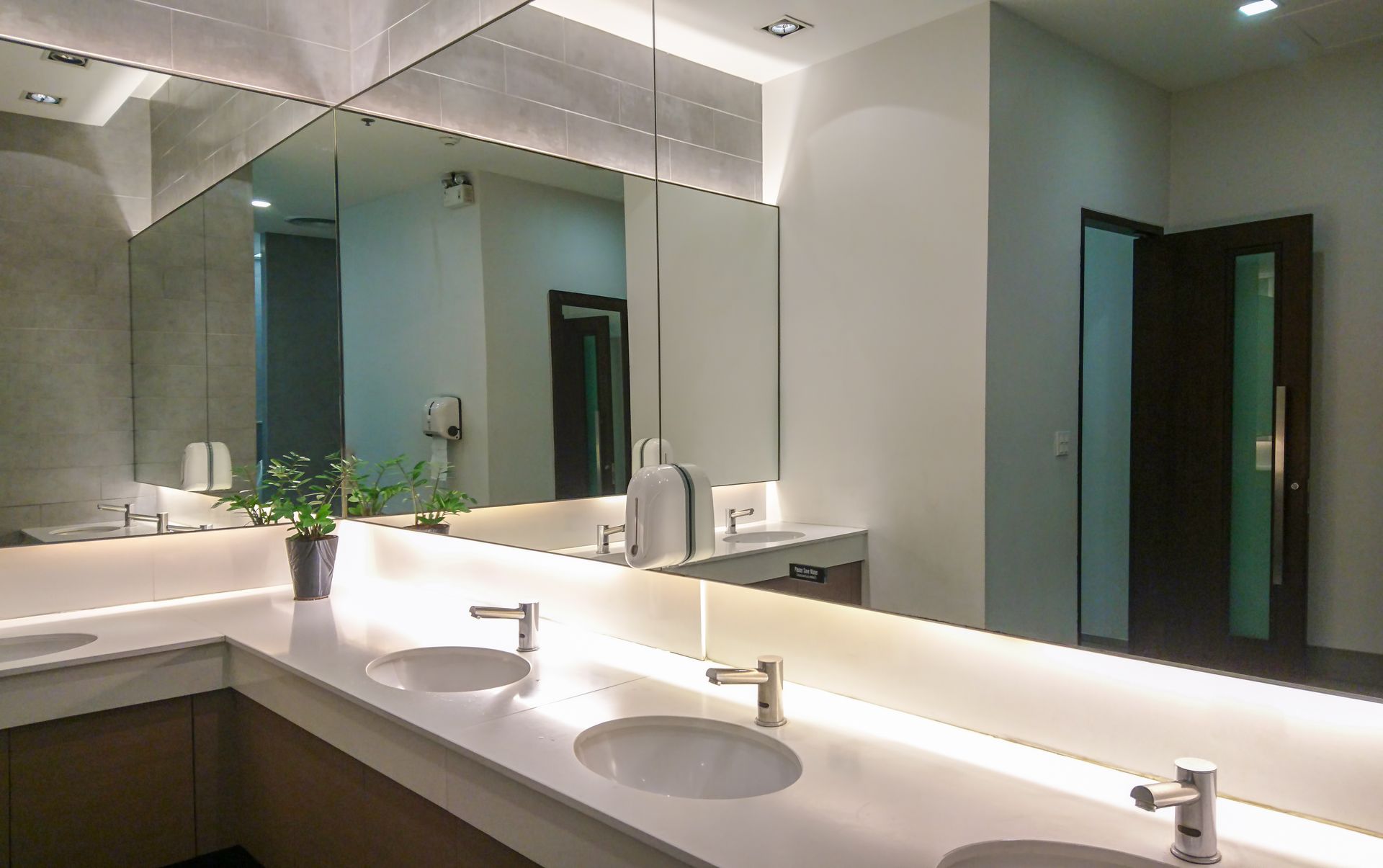 Salle de bains avec deux lavabos et un grand miroir monté sur le mur.