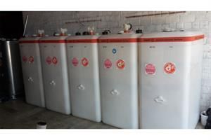 Eine Reihe weißer Tanks, die nebeneinander in einer Garage stehen.