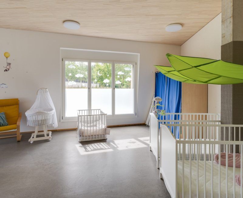 Ein Zimmer mit zwei Kinderbetten und einem gelben Stuhl