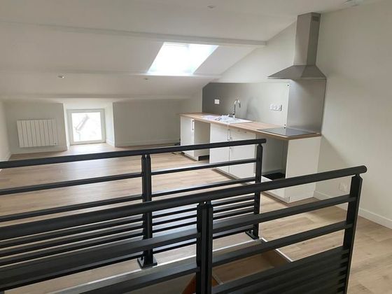 Cuisine de type loft avec rambardes noires, armoires blanches, plafond mansardé et puits de lumière.