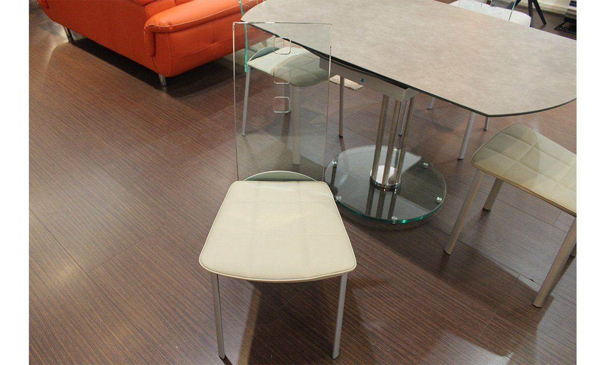 Chaise en cuir blanc et dossier transparent de la marque Pérouse autour d'une table en céramique vue de face