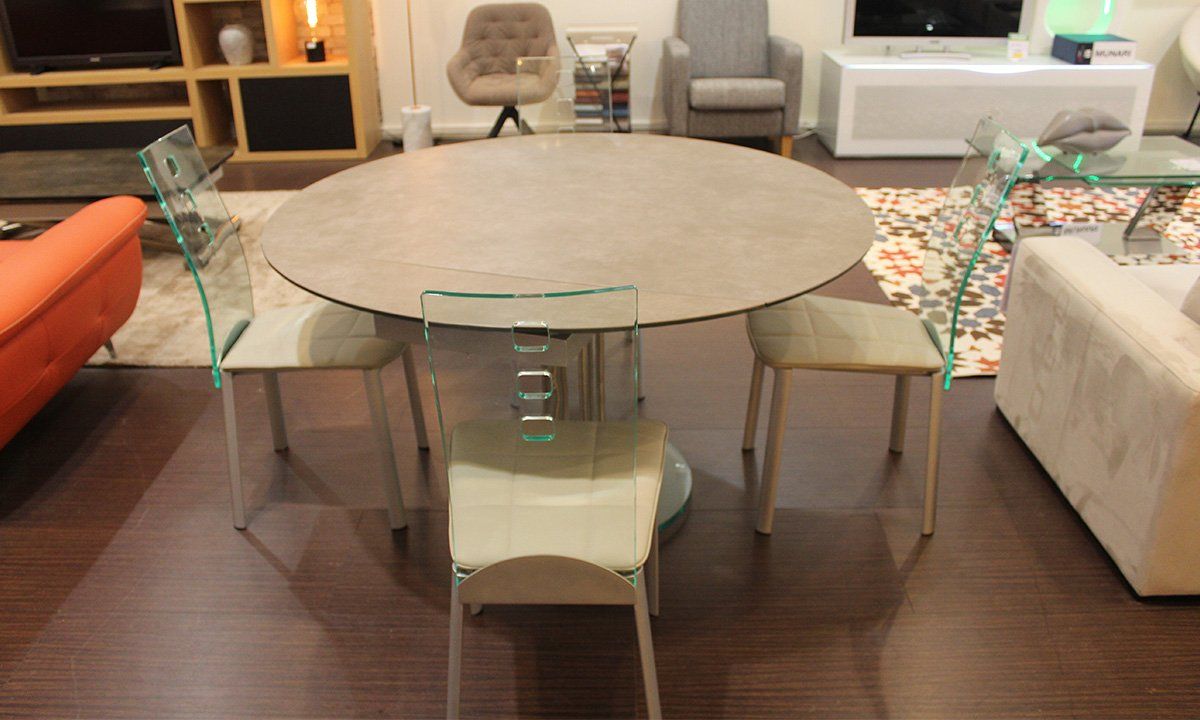 Table de repas ovale extensible de la marque Pérouse entourée de 4 chaises en cuir blanc et dossier transparent