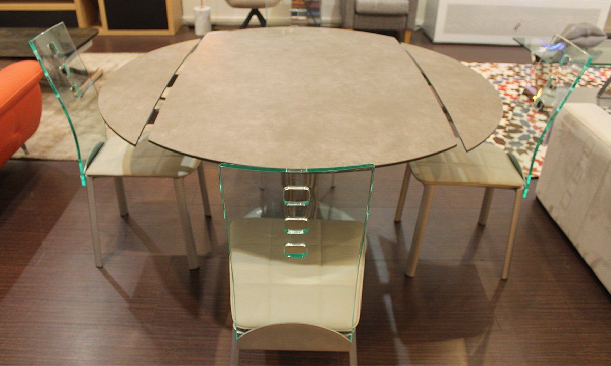 Installation de la table de repas ovale extensible de la marque Pérouse entourée de 4 chaises en cuir blanc et dossier transparent