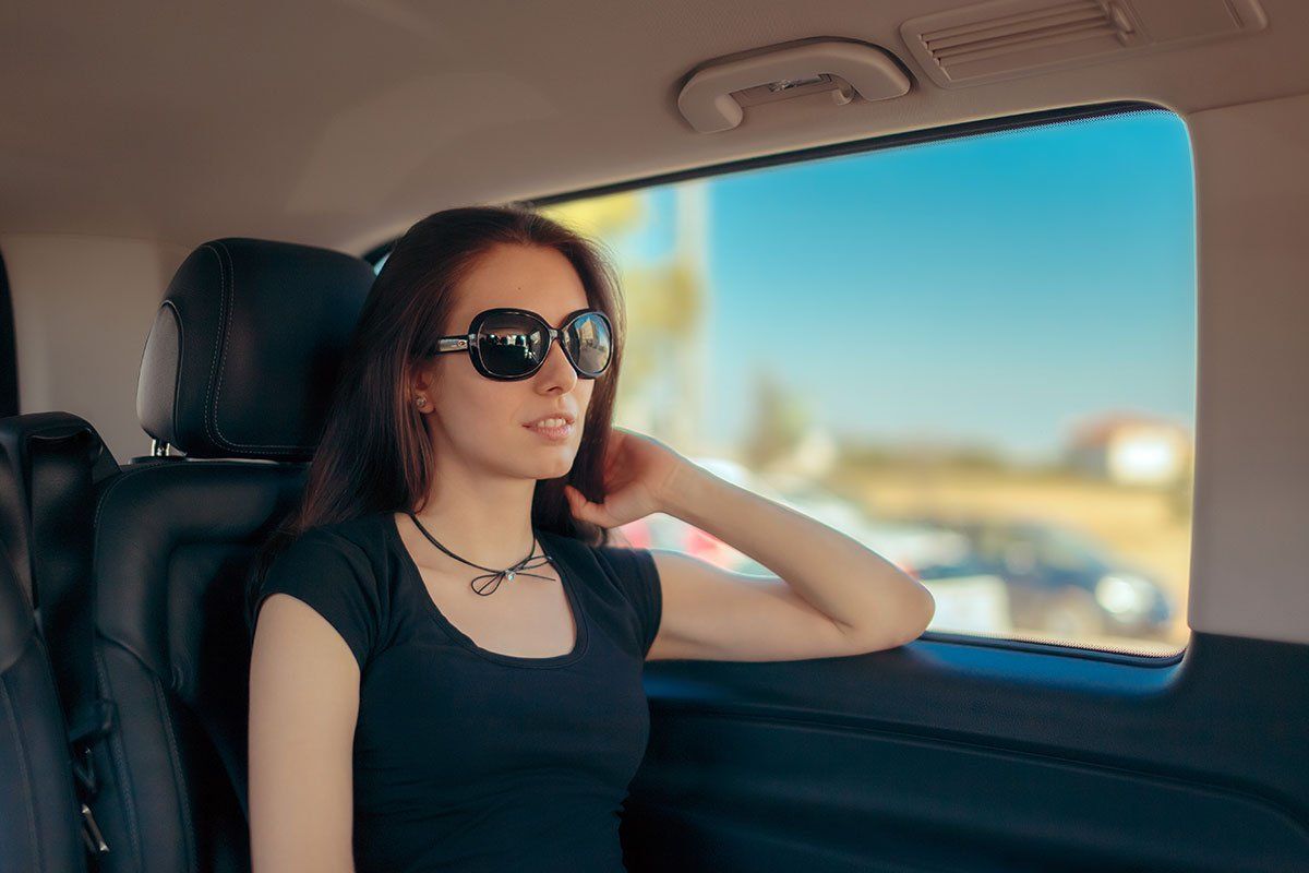 Femme avec des lunettes de soleil assise dans un taxi