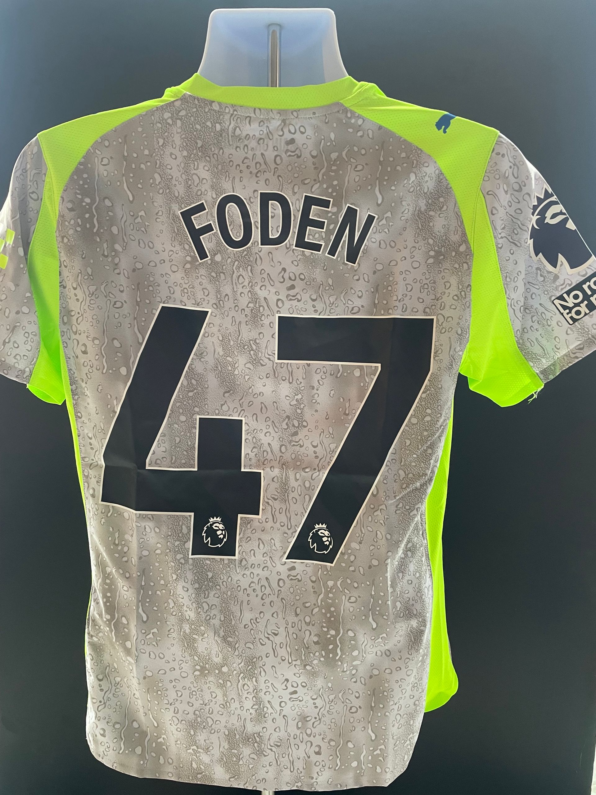 Gray and neon green Etihad Airways soccer jersey on a mannequin, front view