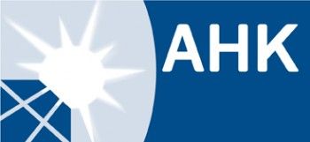 Logotipo azul de AHK con una estrella blanca y líneas cruzadas a la izquierda.