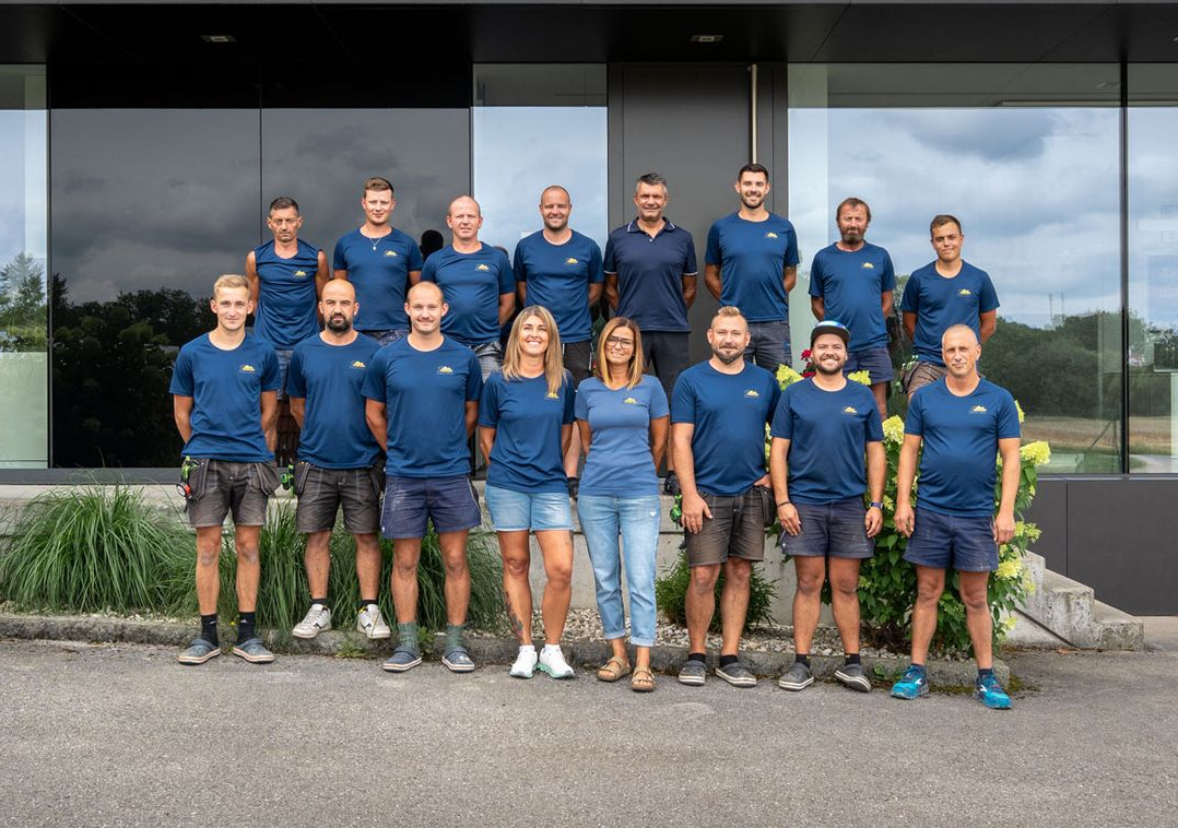 Eine Gruppe von Männern posiert für ein Foto vor einer weißen Tafel