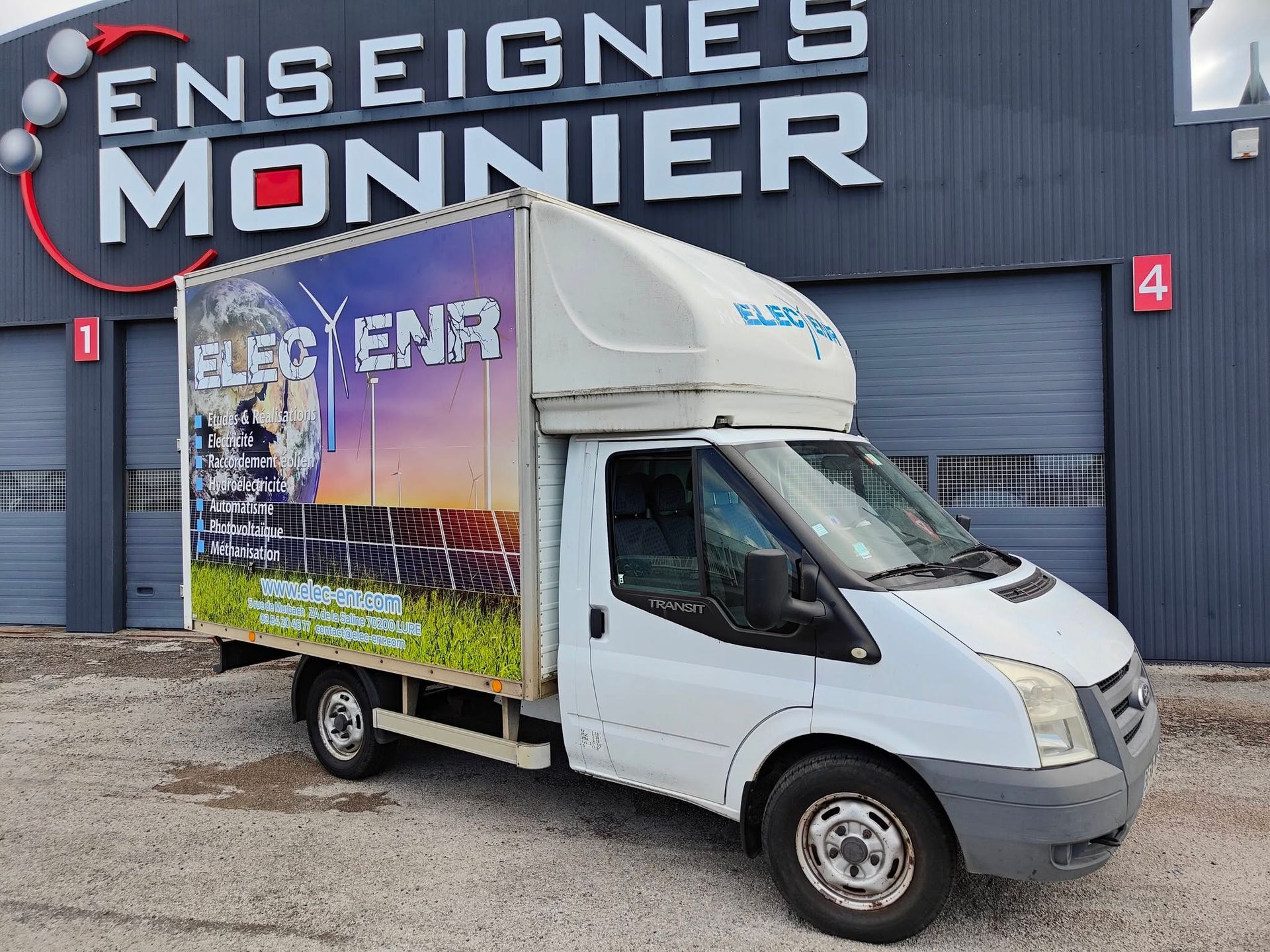 Camion de livraison blanc stationné devant l'entreprise Enseignes Monnier.