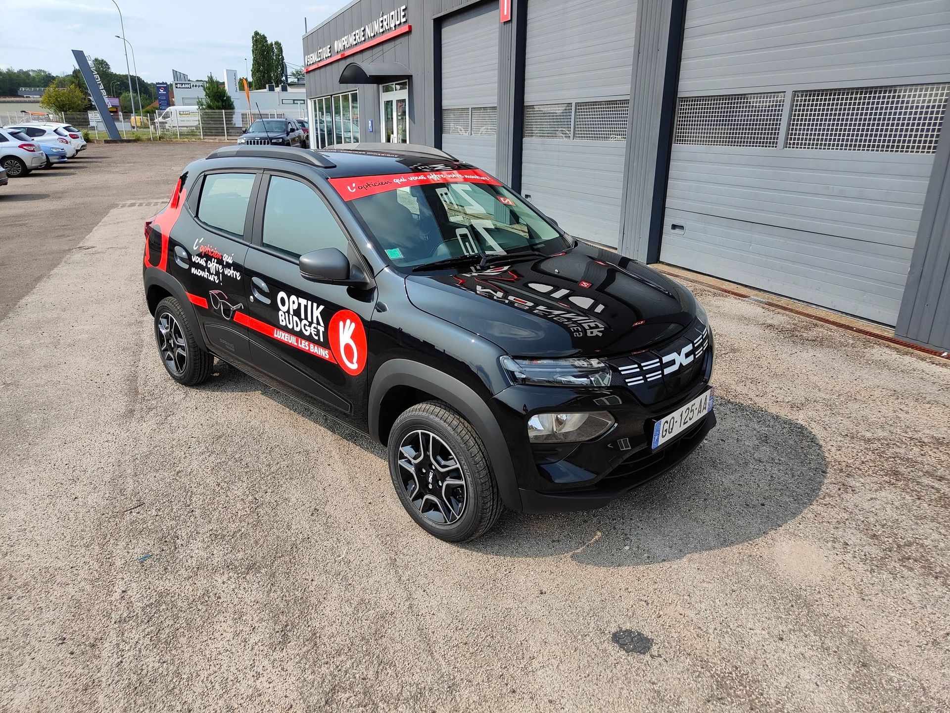 Un SUV compact noir avec des autocollants rouges.