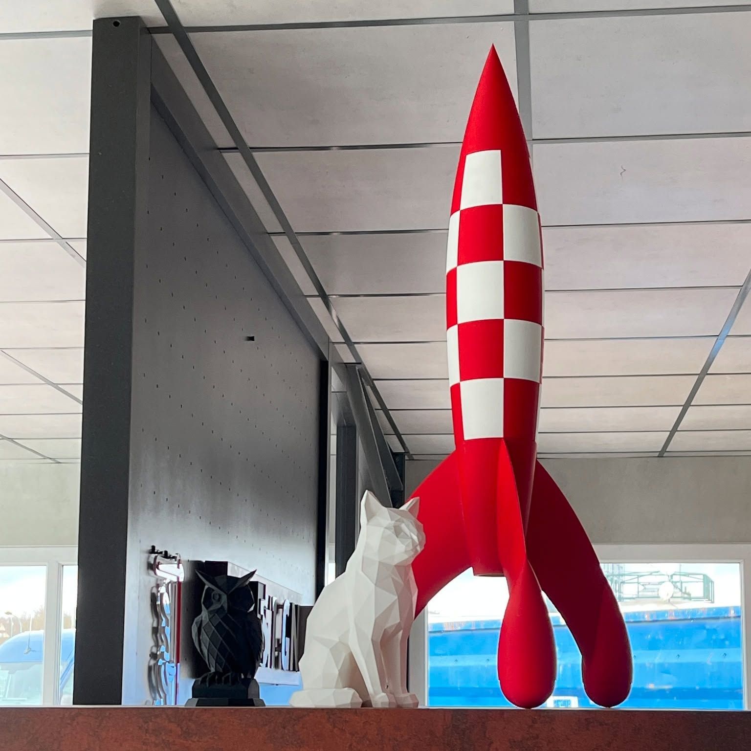 Impression 3D d'une fusée rouge et blanche et d'un chat blanc.