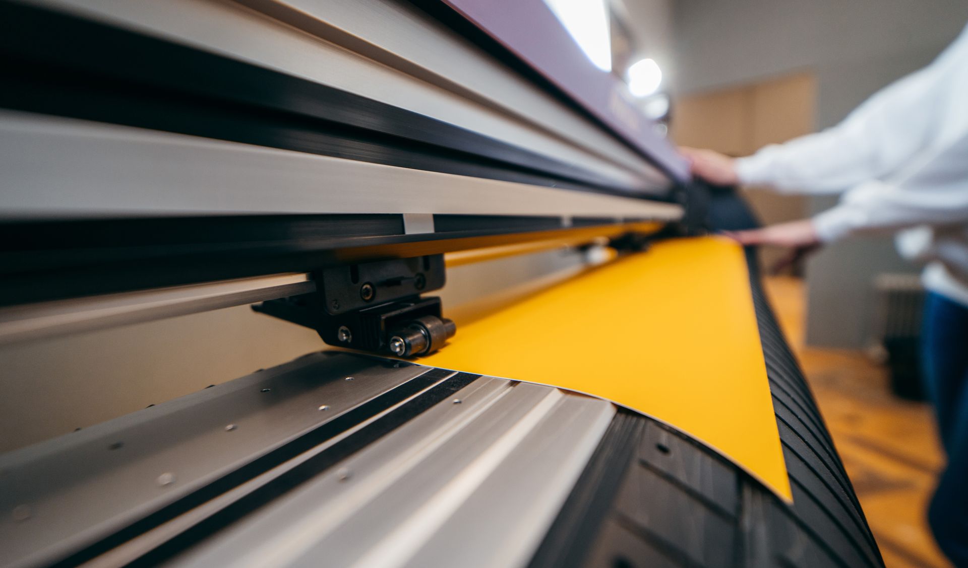 Imprimante grand format produisant une feuille jaune vif dans une imprimerie.