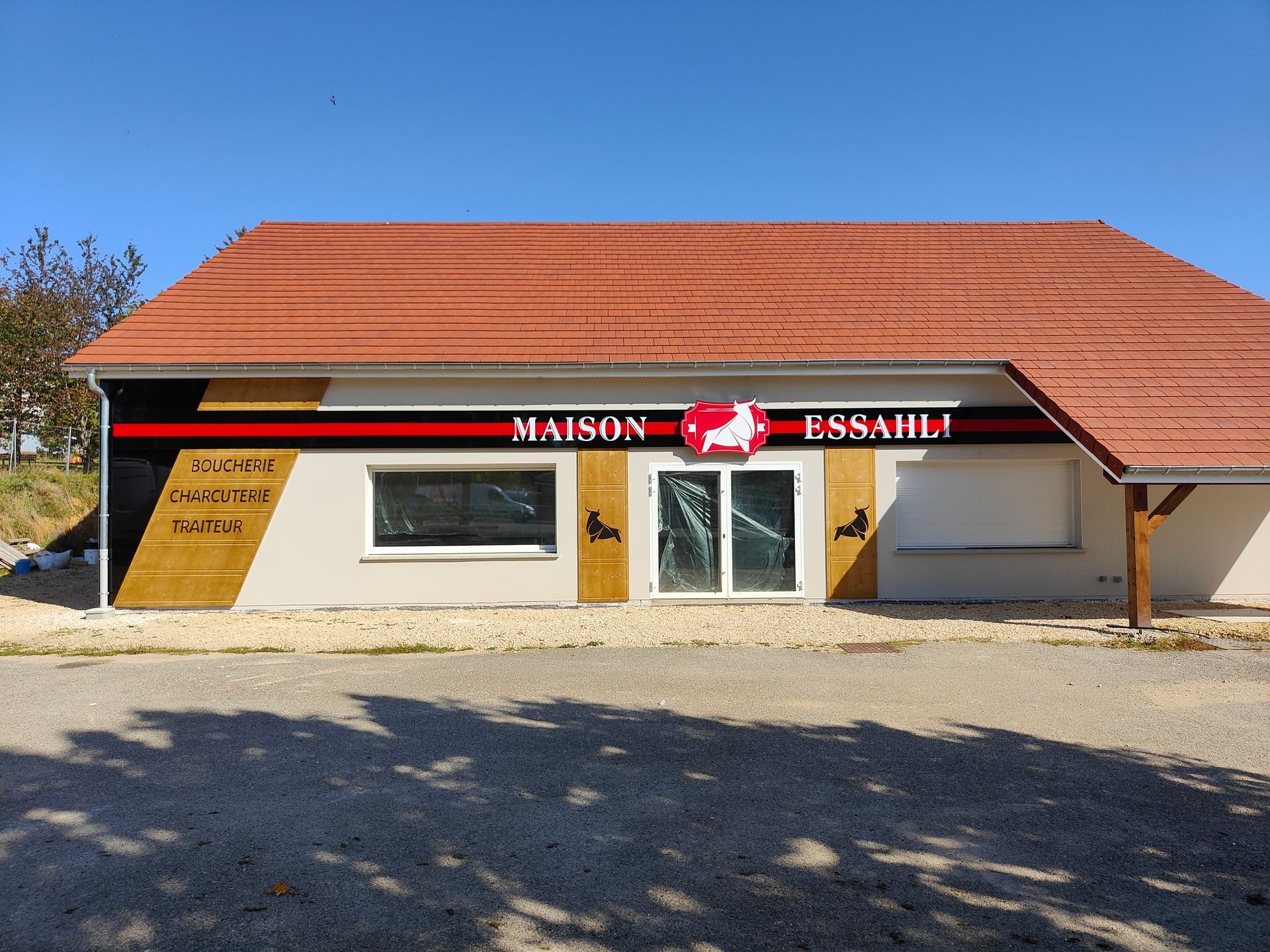 Extérieur de la Pharmacie de la Vallée avec une façade blanche, des portes vitrées et une camionnette garée à proximité.