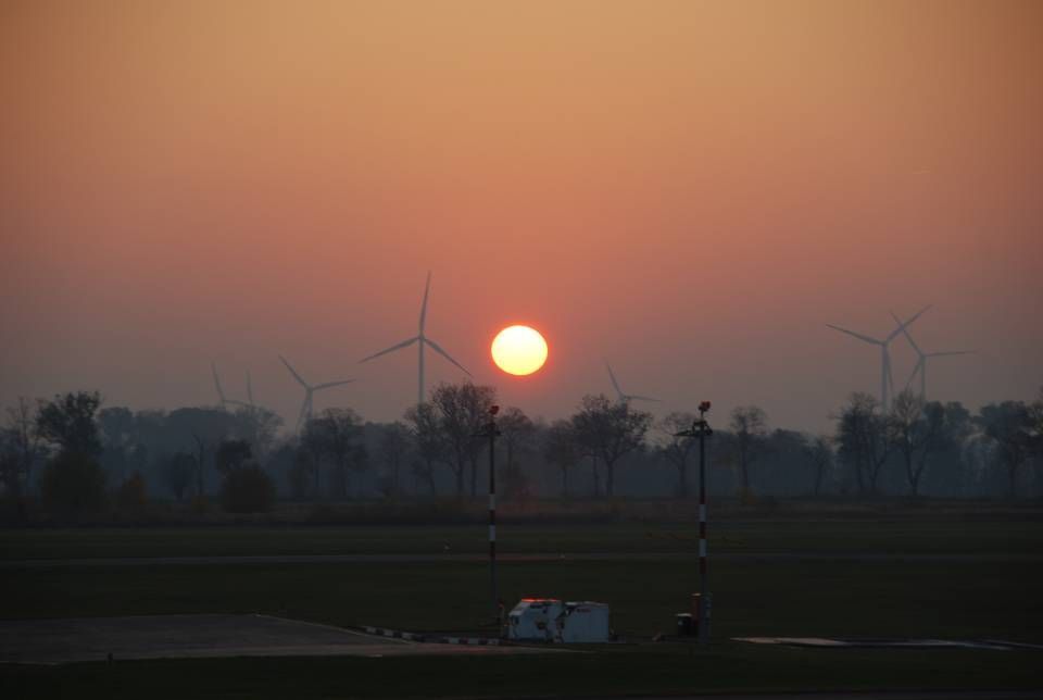Sonnenuntergang und Schemen von Windrädern