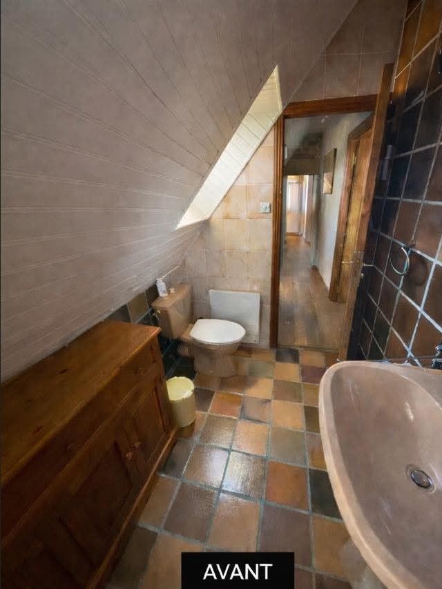 Petite salle de bains vintage avec lavabo sur pied, miroir rond, appliques murales 