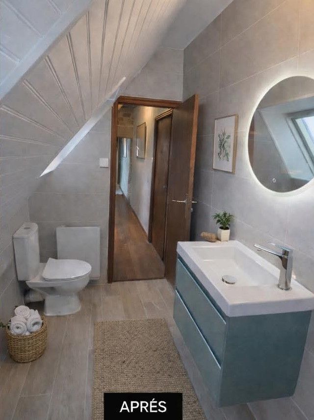 Salle de bains aux murs de pierre avec baignoire en bois, marches, parquet à chevrons