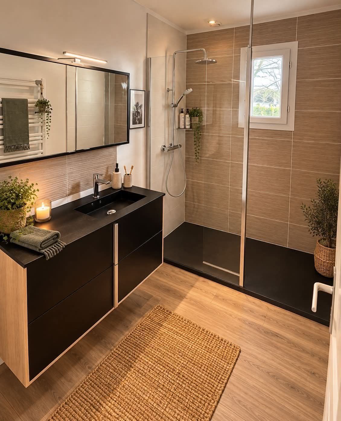 Salle de bains accessible avec toilettes blanches à côté d'une douche en verre et mur en mosaïque bleue