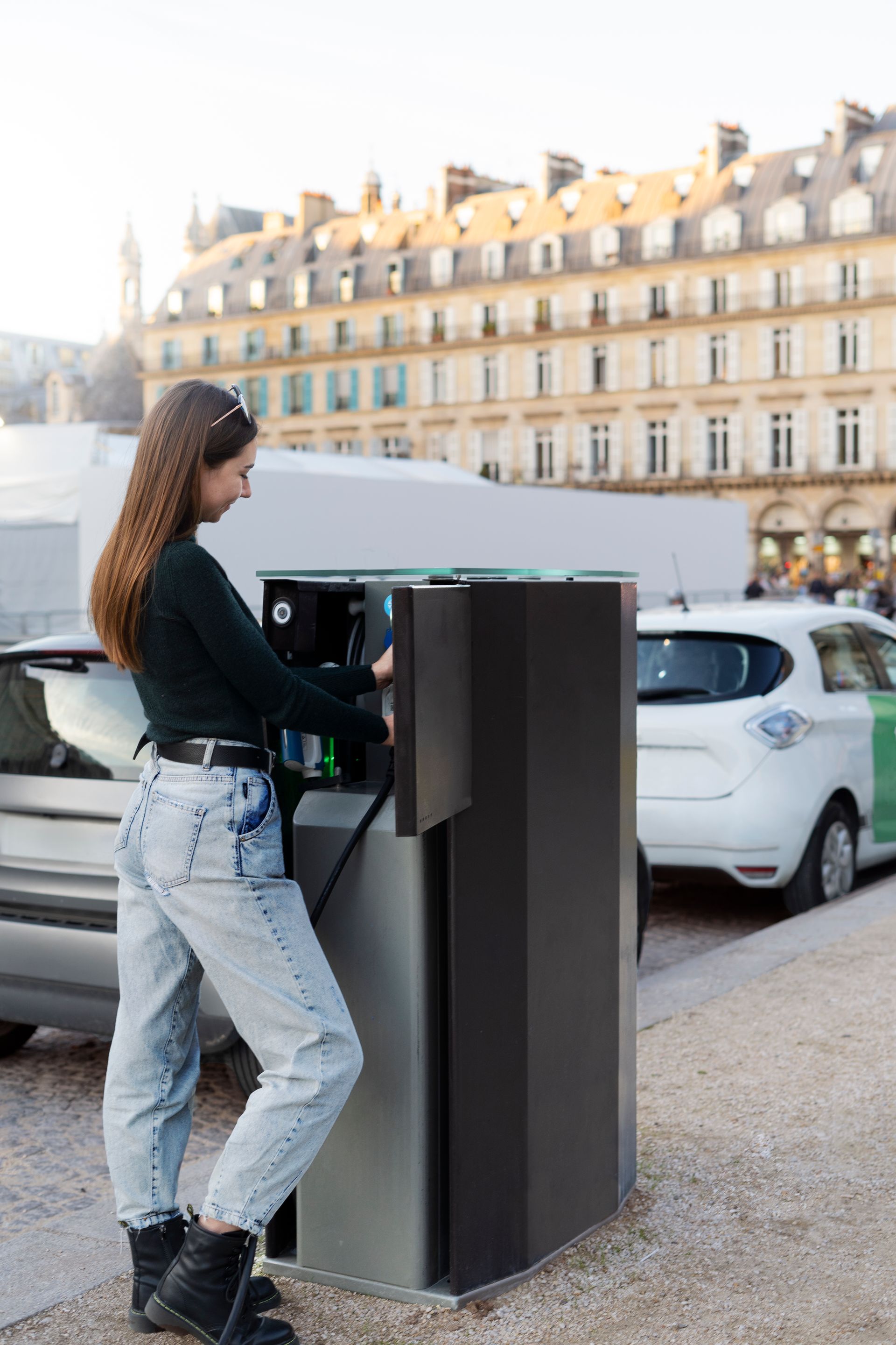 Une personne utilise une borne de recharge publique