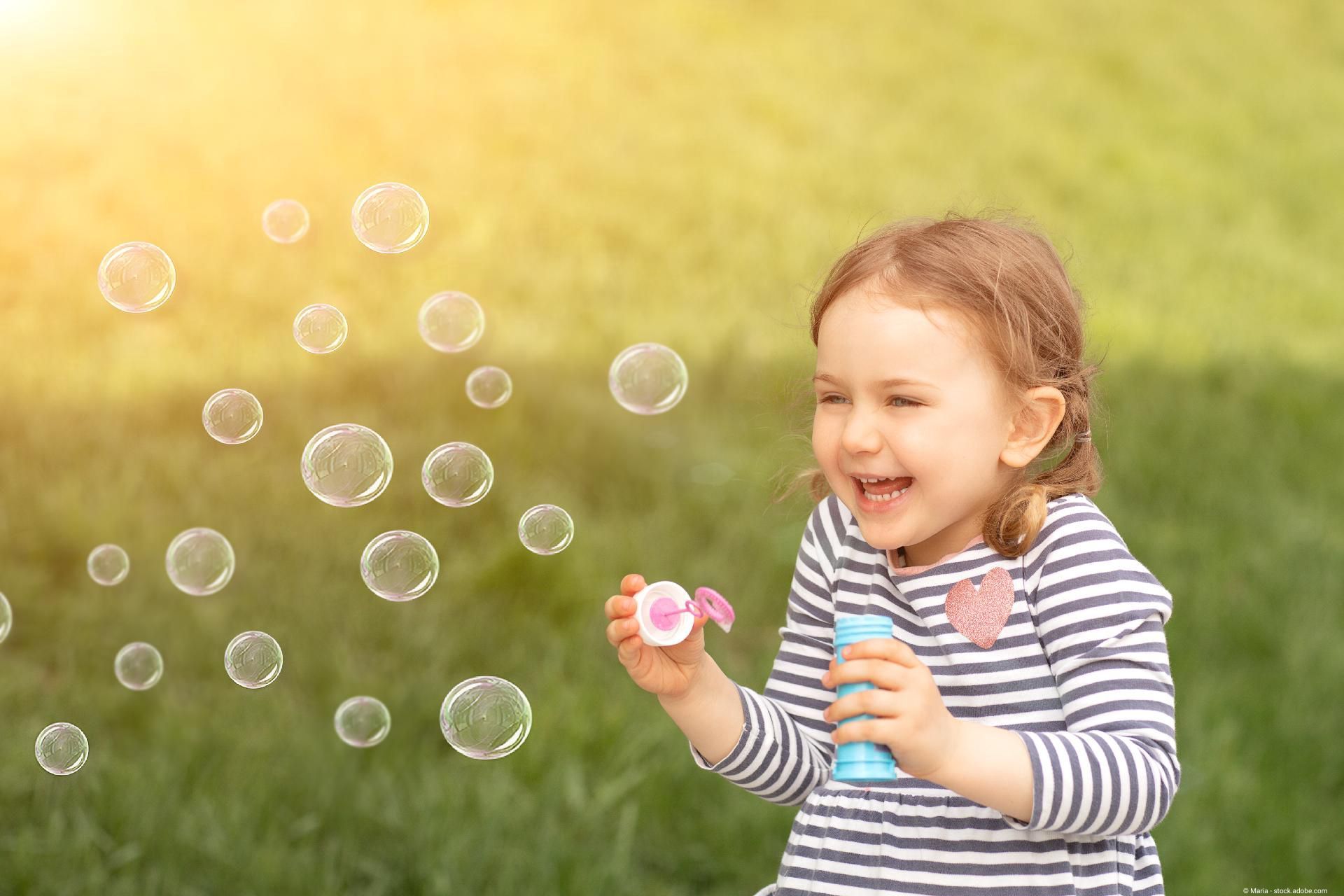 Mädchen spielt mit Seifenblasen.