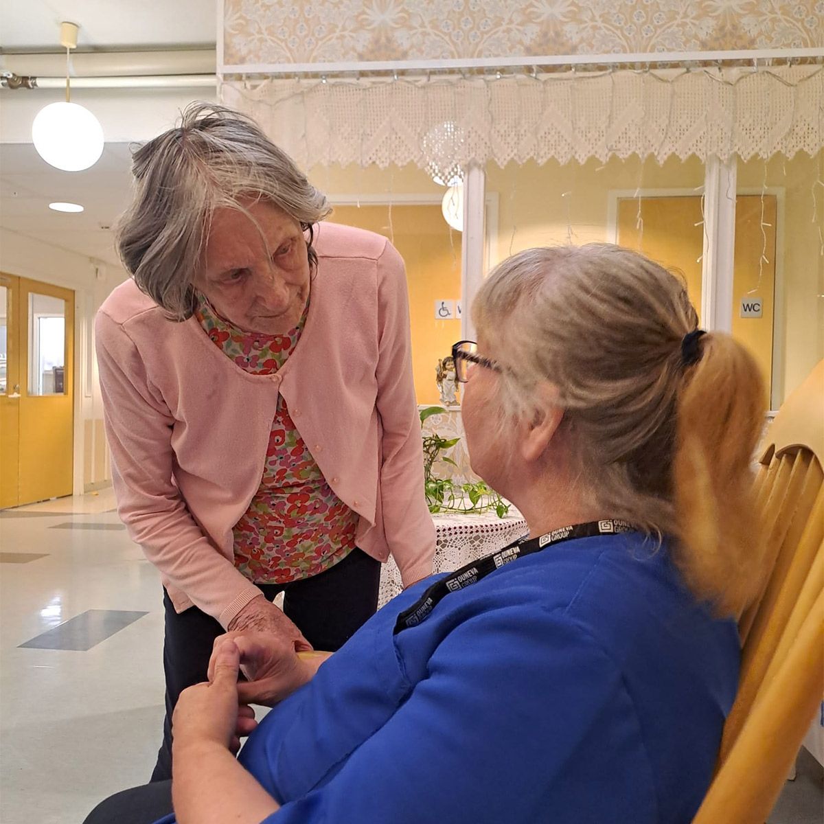 Palvelukodin asukas keskustelemassa hoitajan kanssa.