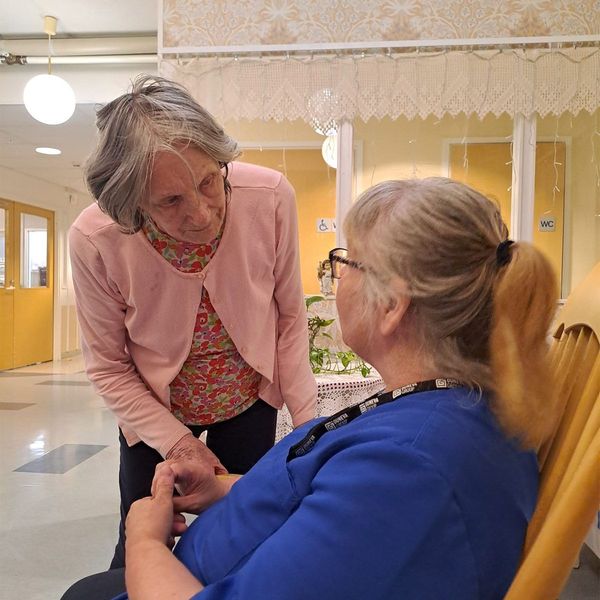 Palvelukodin asukas keskustelemassa hoitajan kanssa.