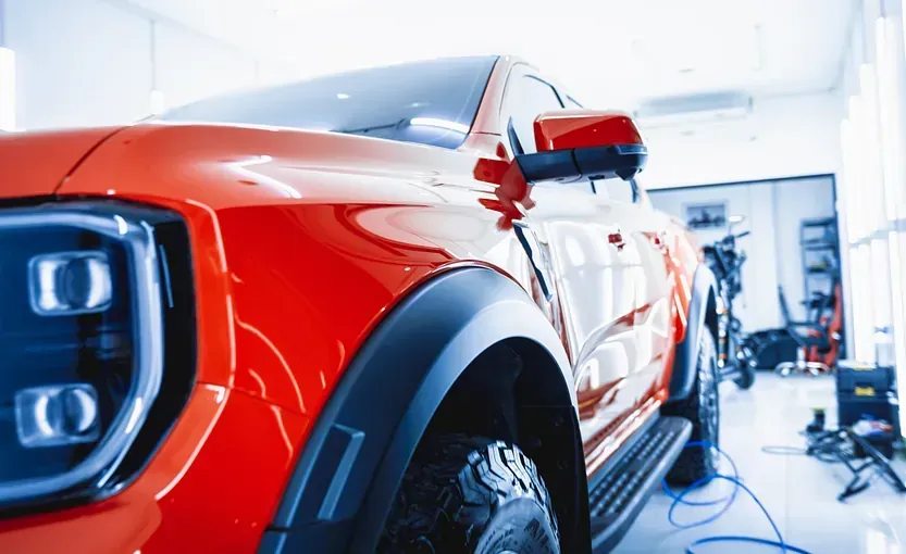 Un primer plano de un coche rojo en un garaje.
