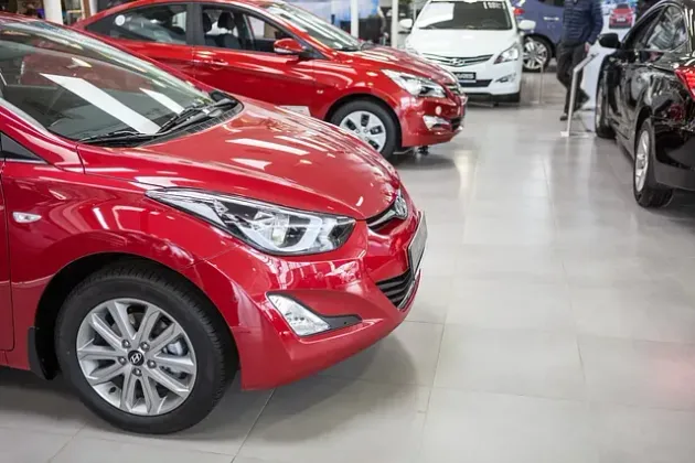 Una fila de coches rojos están aparcados en una sala de exposición.