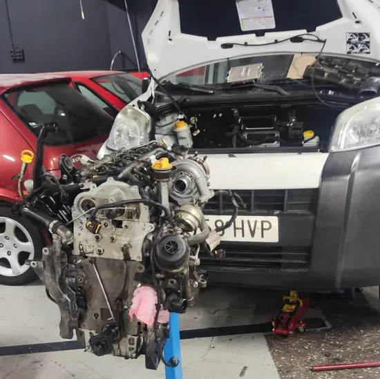 Un coche con el capó levantado tiene una matrícula que dice hvp
