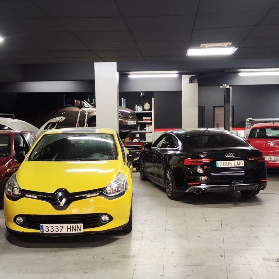 Un coche rojo con el capó levantado en un garaje