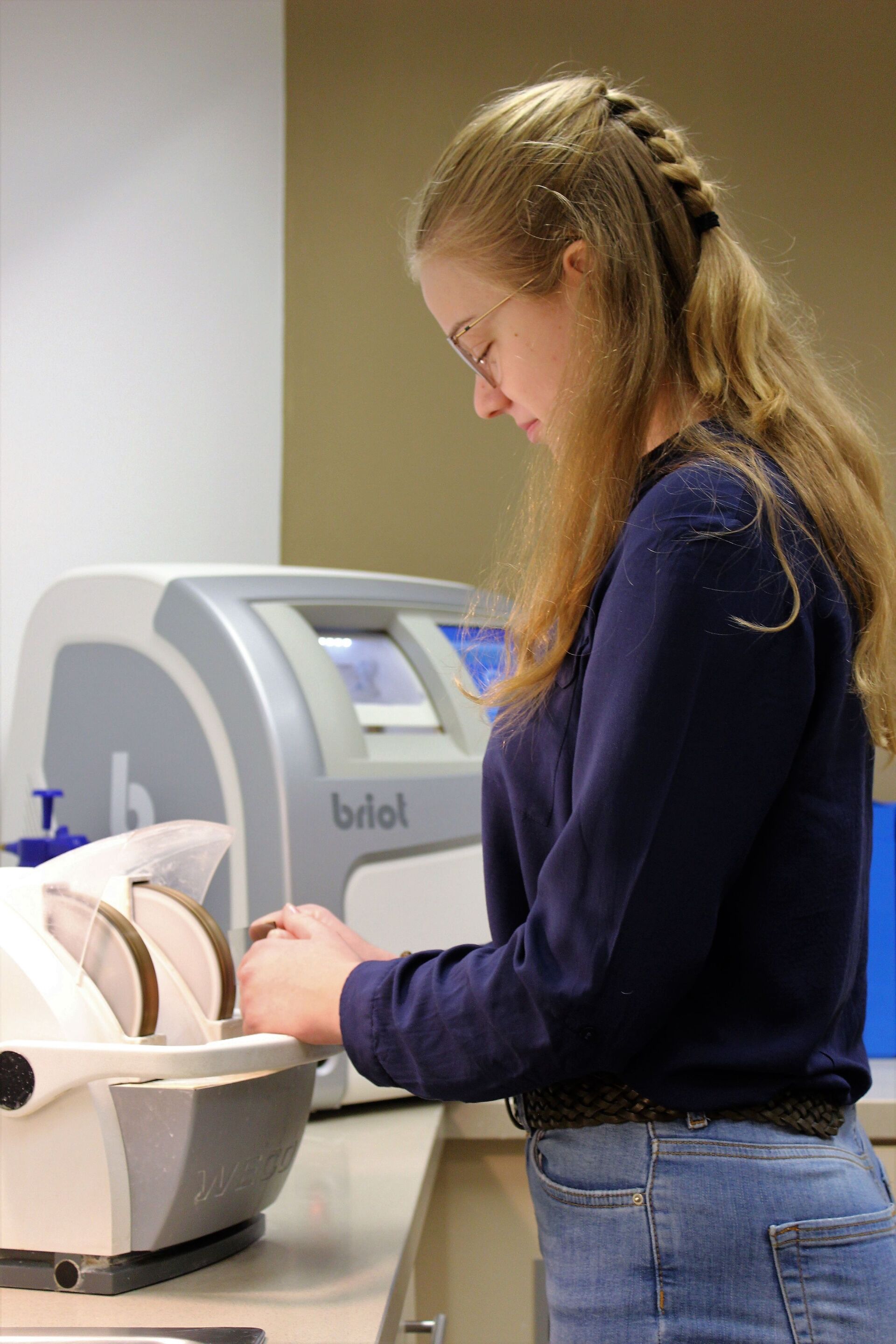 Mitarbeiterin säubert eine Brille