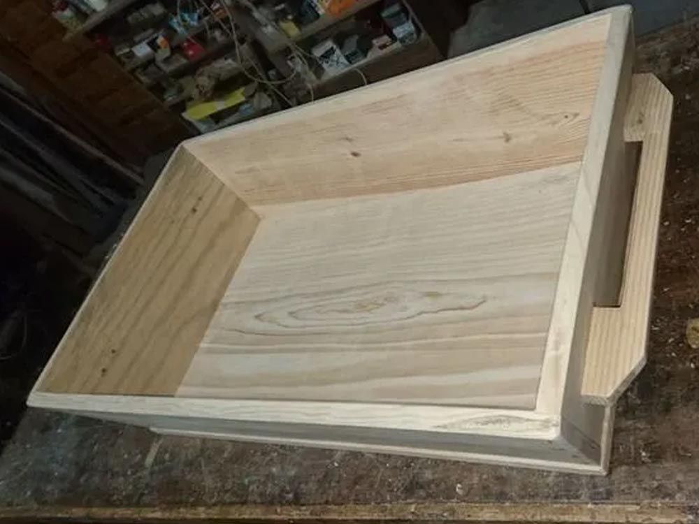 Caja de madera con laterales en ángulo y asa, para interior.