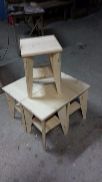 Dos taburetes de madera sin terminar apilados uno encima del otro.