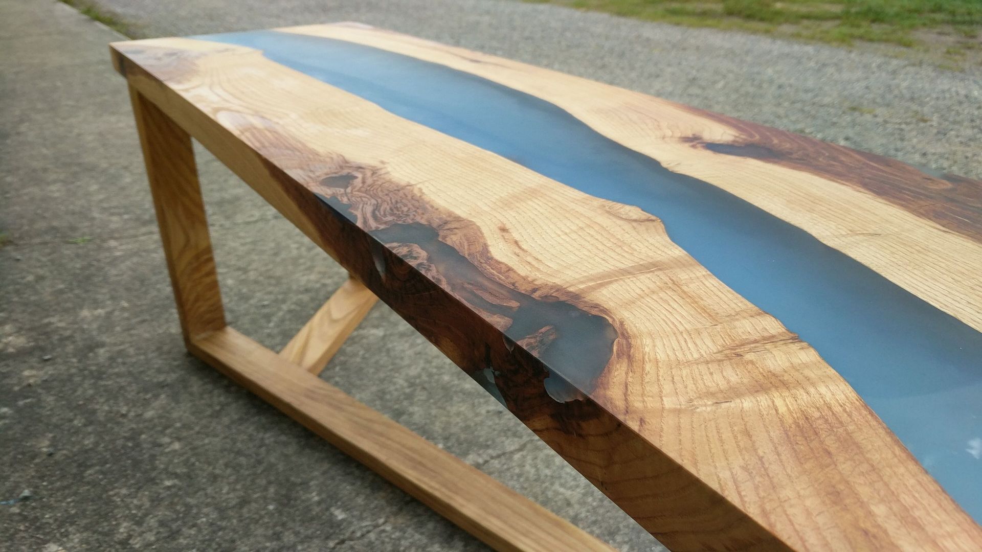 Mesa de madera con un río de resina azul en el medio.