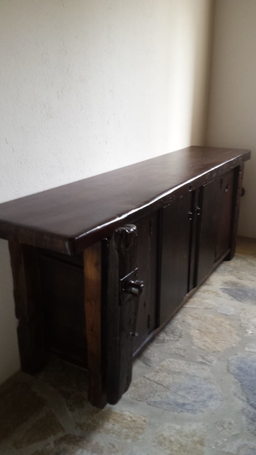 Armario de madera oscura contra una pared clara.