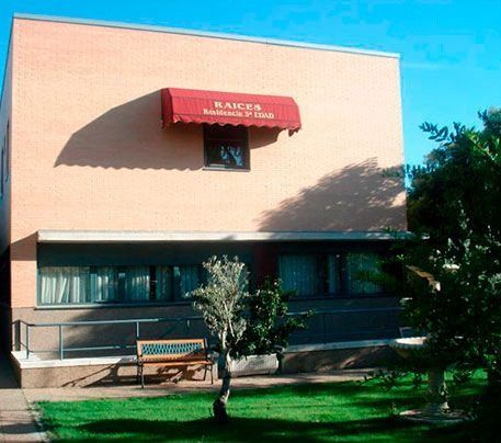 Un edificio con un toldo rojo que dice raíces