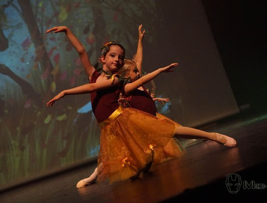 Deux jeunes filles en costumes de danse exécutant un ballet sur scène.