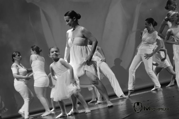 Danseurs en costumes blancs se produisant sur scène.