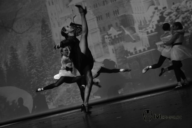 Danseurs de ballet en pleine performance sur scène, avec un château en arrière-plan. Noir et blanc.