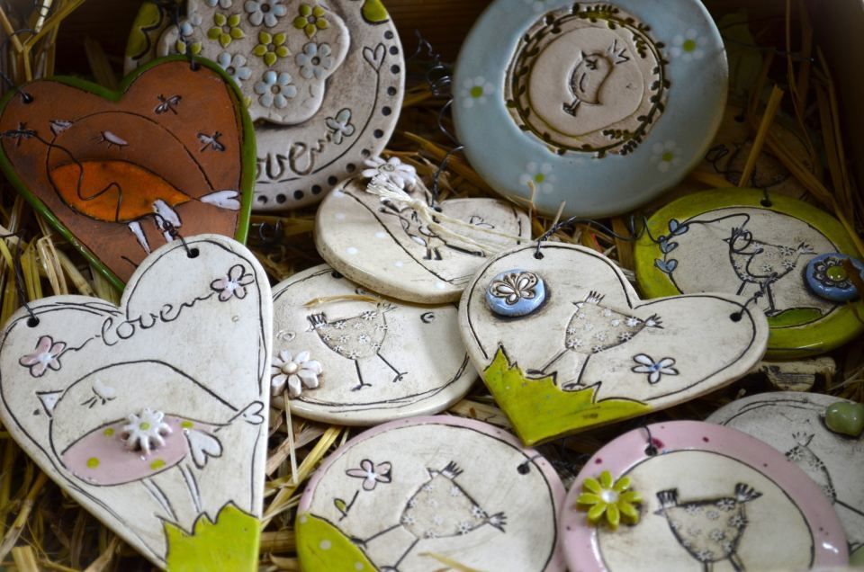 Eine Schachtel gefüllt mit Keramikherzen und Tellern mit Vögeln darauf