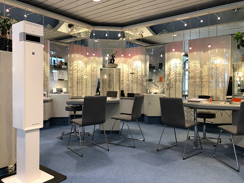 Ein Raum mit Tischen und Stühlen und einer weißen Box in der Mitte