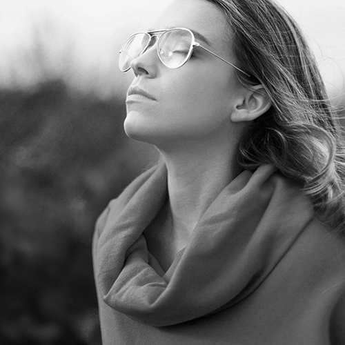 Frau mit Brille und geschlossenen Augen in Natur