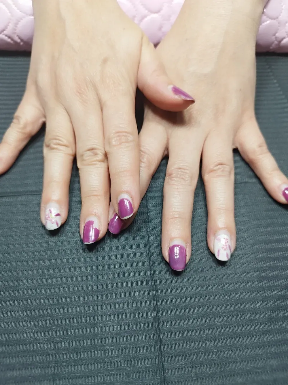 Un primer plano de las manos de una mujer con uñas moradas.