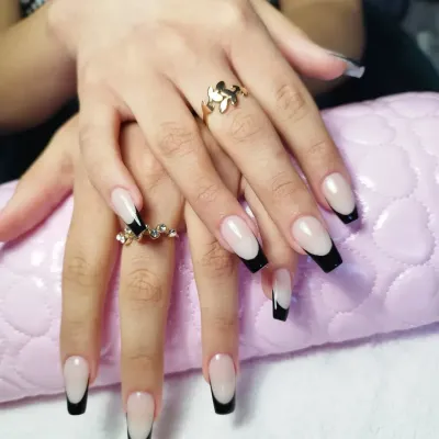 Un primer plano de las uñas de una mujer con un anillo en el dedo.