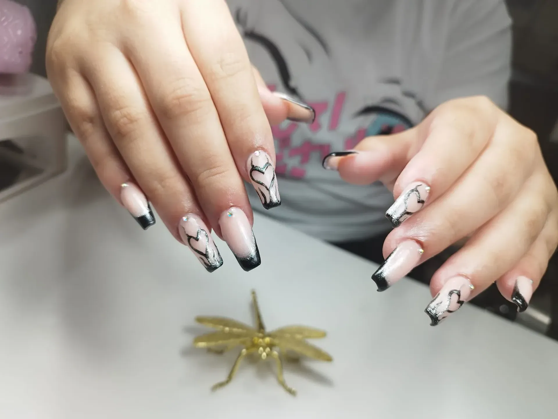 Manos con uñas largas y cuadradas con diseños en blanco y negro