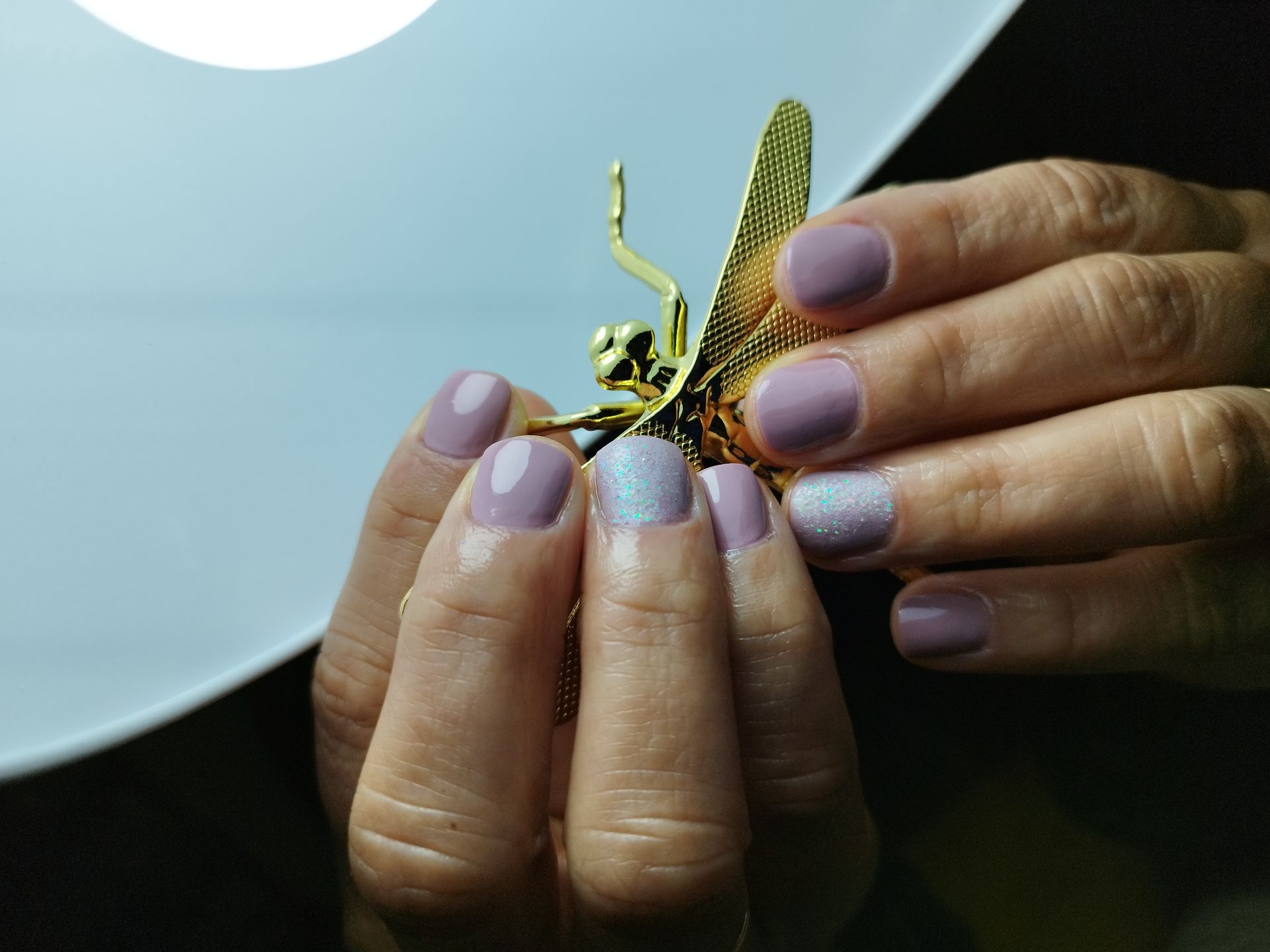 Una persona que lleva guantes rosas sostiene un anillo en su dedo.