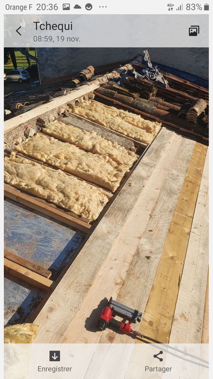 Toiture partiellement construite avec charpente en bois et panneaux isolants disposés en rangées
