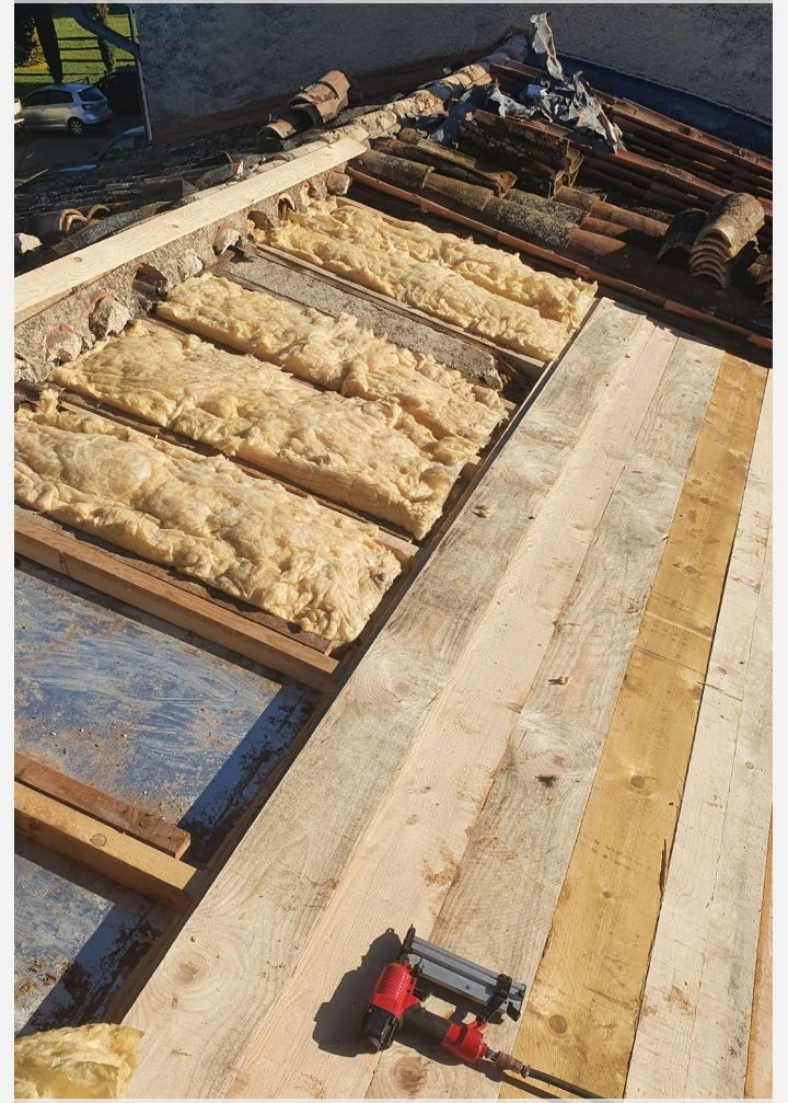 Toiture partiellement construite avec charpente en bois et panneaux isolants disposés en rangées